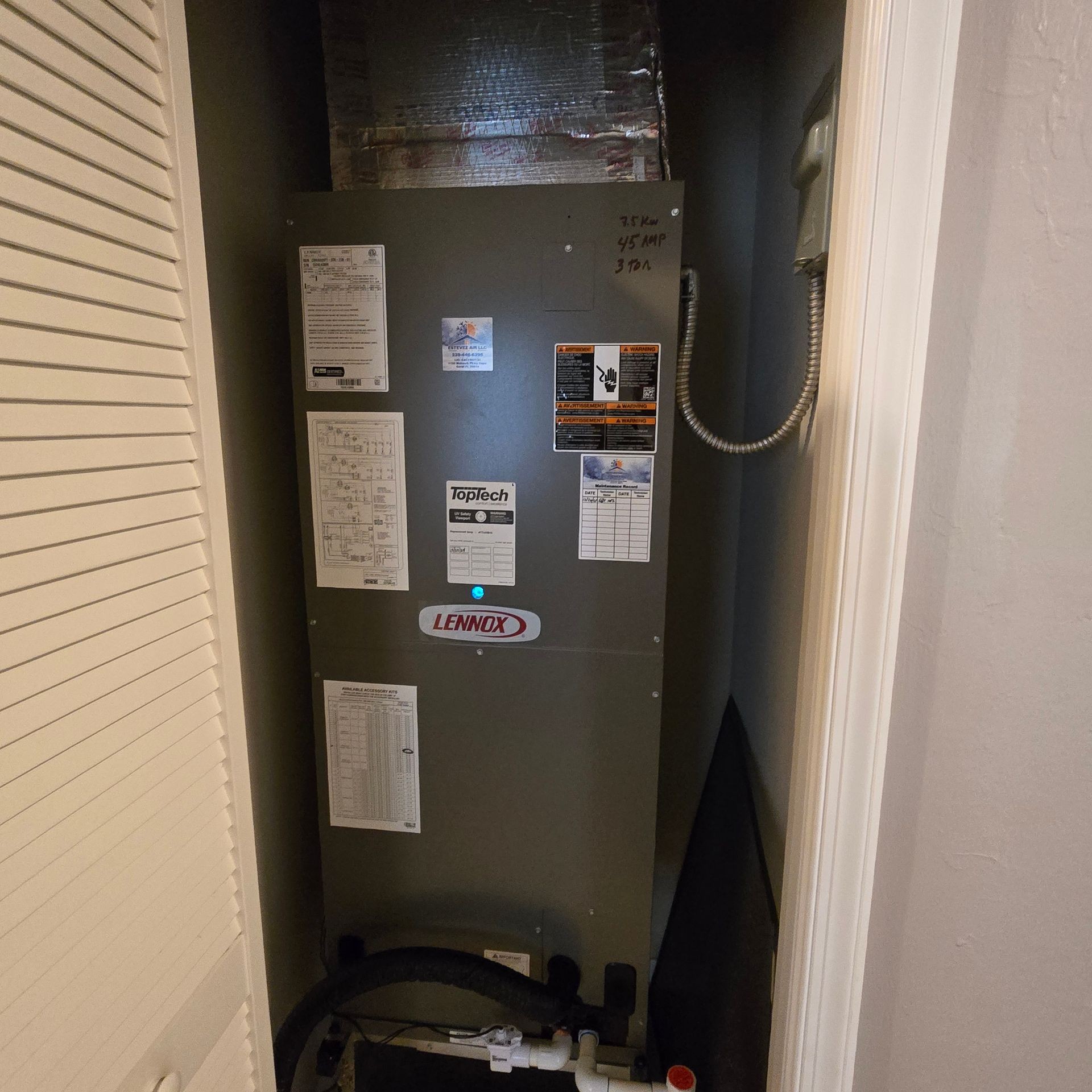 Utility closet containing a Lennox air conditioning unit with visible labels and control panel.